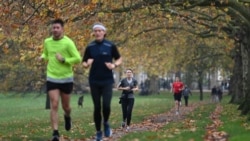 People exercise in Green Park in central London on November 8, 2020 during a second national lockdown designed to contain soaring infections of the novel coronavirus. (Photo by DANIEL LEAL-OLIVAS / AFP)