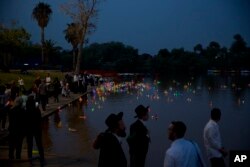 People look upon floating handmade boats with the names of Nazi concentration camps, during a ceremony marking the annual Holocaust Remembrance Day in Hayarkon park in Tel Aviv, Israel, May 1, 2019.