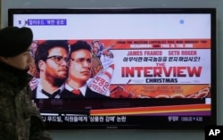 FILE - A South Korean army soldier walks near a TV screen showing an advertisement of Sony Picture's "The Interview," at the Seoul Railway Station in Seoul, South Korea, Dec. 22, 2014.