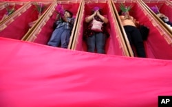 Worshippers pray as they take turns lying in coffins at the Takien temple in suburban Bangkok, Thailand Monday, Dec. 31, 2018.