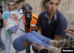 A Palestinian woman affected by tear gas is evacuated by medics during clashes between stone-throwing Palestinians and Israeli police on the compound known to Muslims as Noble Sanctuary and to Jews as Temple Mount in Jerusalem's Old City, Sept. 15, 20