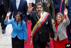 FILE - Venezuela's President Nicolas Maduro, then Constituent National Assembly President Delcy Rodriguez, left, and first lady Cilia Flores, wave as they arrive to the National Assembly, in Caracas, Venezuela, May 24, 2018.