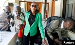 FILE - Kenyan marathon runner Rita Jeptoo walks past photographers as she arrives at the Athletics Kenya headquarters after failing a doping test, in Nairobi, Jan. 15, 2015.