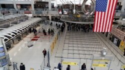 Passengers walk through Terminal 1, after further cases of coronavirus were confirmed in New York, at JFK International Airport in New York, U.S., March 13, 2020. REUTERS