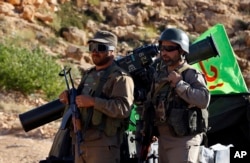 FILE - Hezbollah fighters stand on their army vehicle at the site where clashes erupted between Hezbollah and al-Qaida-linked fighters in Wadi al-Kheil or al-Kheil Valley in the Lebanon-Syria border, July 29, 2017.