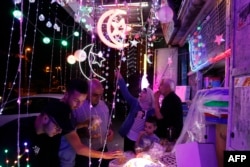 Palestinians check a shop selling Ramadan lights in the old city of Jerusalem, May 4, 2019, as Muslims around the world prepare for the announcement of the fasting month of Ramadan which is expected to start on May 5 or 6 depending on the crescent moon.