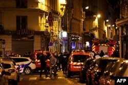 Policemen and emergency service members stand in a blocked street in Paris after one person was killed and several injured by a man armed with a knife, who was shot dead by police, May 12, 2018.