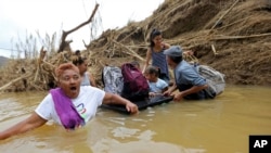 Sebuah keluarga harus seberangi sungai setelah satu jembatan di Puerto Riko putus karena Badai Maria.