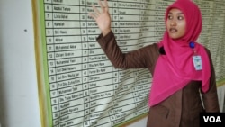Salmi Hardiyanti, now 24, points to the names of nine of her relatives who died in the tsunami. Their bodies have never been found. (Steve Herman/VOA News)