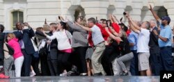 Congressional staffers and guests strain to view and photograph the departure of Pope Francis in his Fiat 500L, on Capitol Hill in Washington after his speech before a joint meeting of Congress, Sept. 24, 2015.