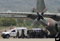 A coffin containing the body of one of the victims of a military helicopter crash in Poso, Central Sulawesi, is loaded into a cargo plane to be transported to Jakarta at the airport in the provincial capital of Palu, Indonesia, March 21, 2016.