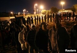 Voters queue to cast their ballots as night falls outside a polling station in Alexandra township in Johannesburg, South Africa, May 8, 2019.