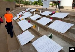 Thomas Baughman, 9, of Dallas, walks past displays with names of people lost to gun violence in Texas, during a protest at City Hall in Dallas, May 4, 2018. The annual National Rifle Association convention is being held nearby at the convention center.