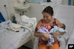 Severina Raimunda holds her granddaughter Melisa Vitoria, left, who was born with microcephaly and her twin brother Edison Junior at the IMIP hospital in Recife, Pernambuco state, Brazil, Wednesday, Feb. 3, 2016.