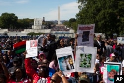 People cheer during a rally to mark the 20th anniversary of the Million Man March in Washington, Oct. 10, 2015.