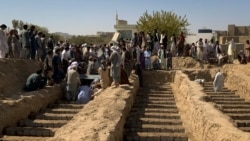 FILE - Relatives carry the body of one of dozens of victims of a suicide attack, during a mass funeral in Kandahar, Afghanistan, Oct. 16, 2021.