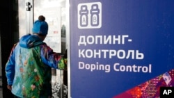 FILE - A man walks past a sign reading "Doping Control" in Russian at a 2014 Sochi Winter Olympics site in Krasnaya Polyana, Russia. Feb. 21, 2014. Moscow has been under fire for months over allegations of state-run doping.
