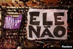 People carry a banner reading "Not Him" during a demonstration against Brazilian presidential candidate Jair Bolsonaro, in Sao Paulo, Brazil, Sept. 29, 2018.