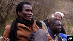 FILE - Hilarion Charlemagne rest on his way to the Greek-Macedonian border near the town of Evzonoi, Greece, Feb. 28, 2015.
