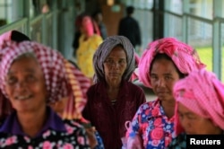 FILE - Women arrive at the entrance gate to the Extraordinary Chambers in the Courts of Cambodia (ECCC) for the trial hearing on evidences of forced marriage and rape during the Khmer Rouge regime, on the outskirts of Phnom Penh, Cambodia, Aug. 23, 2016.