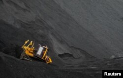 Seorang buruh mengoperasikan buldoser di atas tumpukan batu bara di tambang Vorgashorskaya di luar kota paling utara Vorkuta, Rusia, 17 September 2018. (Foto: Reuters)