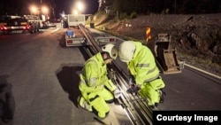 Engineers work to install an electrified track along a highway near Arlanda airport outside Stockholm, Sweden. (eRoadArlanda)