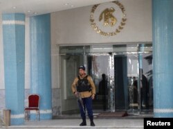 An Afghan security guard stands at the entrance gate of the Intercontinental Hotel after an attack in Kabul, Afghanistan Jan. 23, 2018