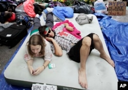 FILE - Robert Grodt, right, and Amber Oestreich, who are part of the protest movement Occupy Wall Street, rest on a mattress in New York's Zuccotti Park, Sept. 26, 2011.