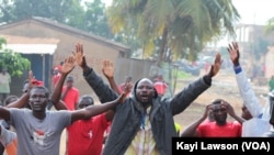 Mains levées, quelques manifestants essaient d’entamer une marche avant d’être dispersés à Lomé, Togo, 19 août 2017. (VOA/Kayi Lawson)