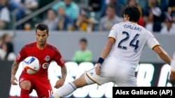 Los Angeles Galaxy midfielder Stefan Ishizaki (24) battles Toronto FC midfielder Sebastian Giovinco, left, for the ball during the first half of an MLS soccer game in Carson, Calif., Saturday, July 4, 2015. The Galaxy won 4-0.