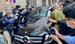 代表李宇轩的事务律师陈天立及大律师罗达雄乘车离开法院大楼时，被大批记者包围追访，场面一度混乱，后来有警车协助开路离开 (美国之音/汤惠芸）