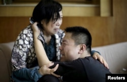 Family members of passengers on the ship which sank at the Jianli section of Yangtze River, in Hubei province, cry outside a closed office of Xiehe Travel in Shanghai, China, June 2, 2015.