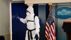 A member of the White House cleaning staff sprays the press briefing room the evening of U.S. President Donald Trump's return from Walter Reed Medical Center after contracting the coronavirus disease (COVID-19), in Washington, U.S., October 5, 2020.