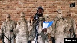 FILE - Leader of one of the Boko Haram group's factions, Abubakar Shekau speaks in front of guards in an unknown location in Nigeria in this still image taken from an undated video obtained on Jan. 15, 2018.