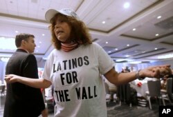 FILE - Republican presidential candidate Donald Trump supporter Luisa Aranda gestures as she is interviewed before Trump spoke at the California Republican Party 2016 Convention in Burlingame, Calif.