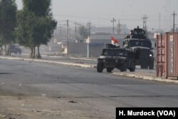 Army vehicles race back from the battle front deeper in the city in Gogjali, Mosul, Iraq, Nov. 7, 2016.