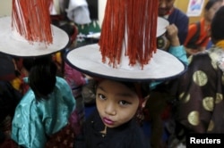 A young Tibetan exile stands backstage as she waits to perform during celebrations marking the 80th birthday of exiled Tibetan spiritual leader Dalai Lama, at Majnu Ka Tila, a Tibetan refugee camp in New Delhi, India, July 6, 2015.