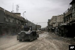 FILE - A humvee of the Iraqi Federal Police drives through an abandoned street in western Mosul, Iraq, May 2, 2017.