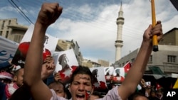 Demonstrators, one painting his national flag and Arabic that reads "Muath," chant anti-Islamic State group slogans and carry posters with pictures of slain Jordanian pilot, Lt. Muath al-Kaseasbeh, during an anti-IS group rally in Amman, Jordan, Feb. 6, 2015.