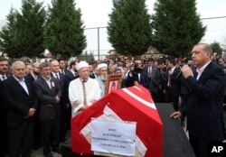 Turkey's President Recep Tayyip Erdogan, right, speaks during the funeral of Fatih Safiturk, the district governor of the town of Derik in southeast Turkey, in Sakarya, Turkey, Nov. 12, 2016. Safiturk died of wounds suffered in an attack by Kurdish militants on a