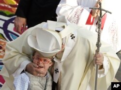 Pope Francis greets a child as he walks in procession at the Basilica of the Virgin of Guadalupe before celebrating Mass in Mexico City, Feb. 13, 2016.