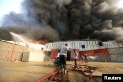 FILE - A crew battles a fire engulfing a warehouse of the World Food Program in Hodeida, Yemen, March 31, 2018.