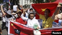Protesters hold banners while chanting slogans during an anti-China protest along a street in Hanoi, July 22, 2012.