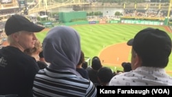 Michelle Boehm, a mentor and friend of Kazam Hashimi's family, attend Hello Neighbor’s Refugee and Immigrant Night at PNC Park, a first for the Pittsburgh Pirates baseball organization, Aug. 1, 2017, in Pittsburgh.