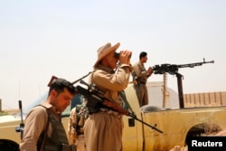 Members of Kurdish security forces patrol after clashes with the militants of the Islamic State of Iraq and the Levant (ISIL), in the village of Basheer, south of the city of Kirkuk, Iraq, June 29, 2014.