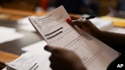 In this Aug. 30, 2017, photo, probation officer Stephanie Pope-Earley sorts through defendant files scored with risk-assessment software on the first day of the software's use at the Cleveland Municipal Court. (AP Photo/Dake Kang)