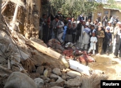 FILE - Students gather at the site of a U.S. drone strike on an Islamic seminary in Hangu district, bordering North Waziristan, Pakistan, Nov. 21, 2013. The strike killed a senior member of the Taliban-linked Haqqani network, Pakistani and Afghan sources