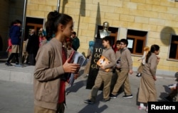 FILE - Students of Tevfik Ileri Imam Hatip School walk past a statue of Mustafa Kemal Ataturk, founder of secular Turkey, in Ankara, Turkey, Nov. 18, 2014.