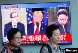 Women walk past a TV broadcast about the canceled summit between the U.S. and North Korea, in Seoul, South Korea, May 25, 2018.