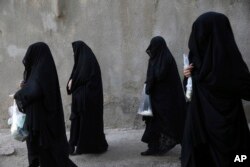 Veiled Iranian women take part in a mourning ceremony for Ashoura on Oct. 11, 2016, symbolically covering their faces in the city of Khorramabad, southwest of the capital Tehran, Iran.